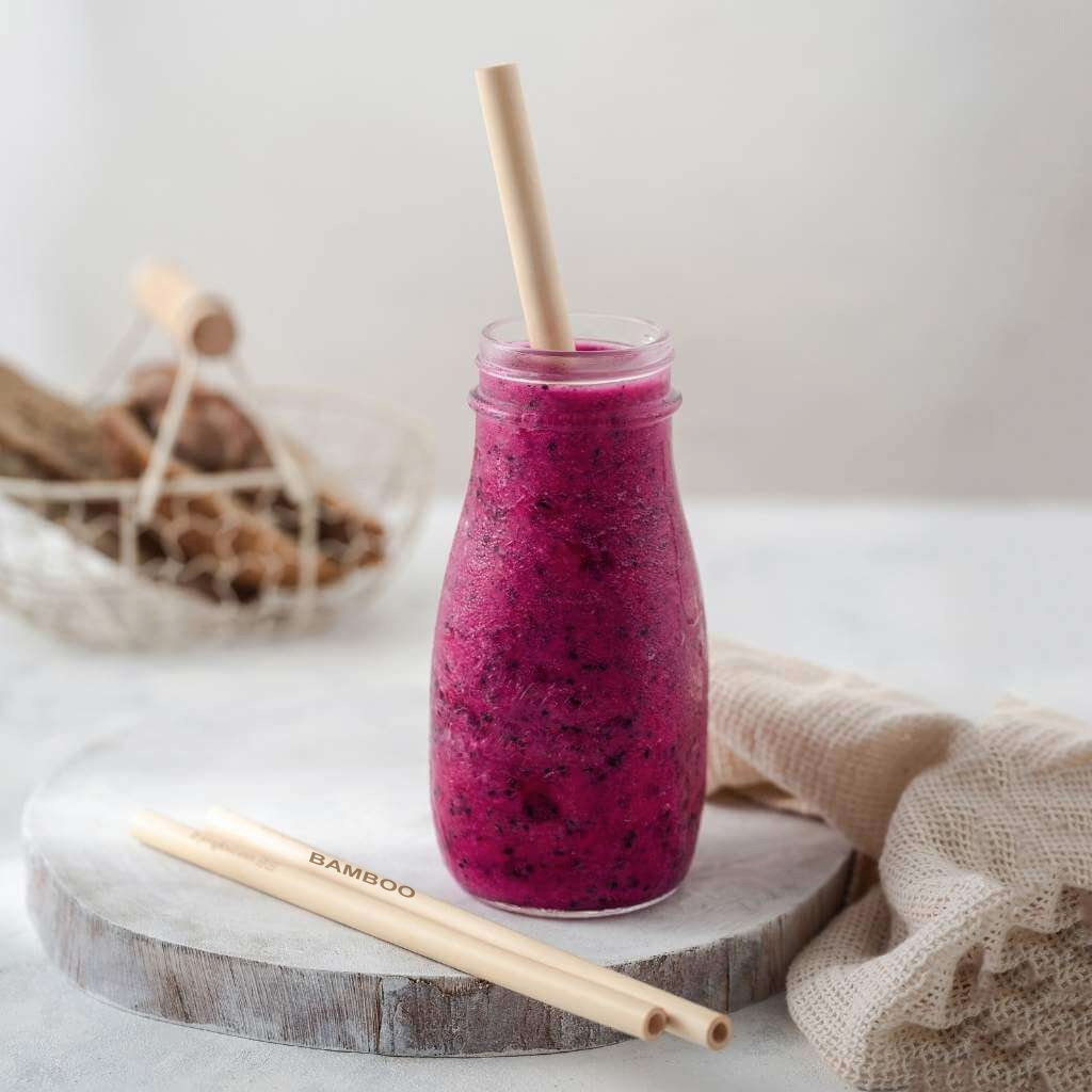 Bamboo straws beside a colorful morning smoothie