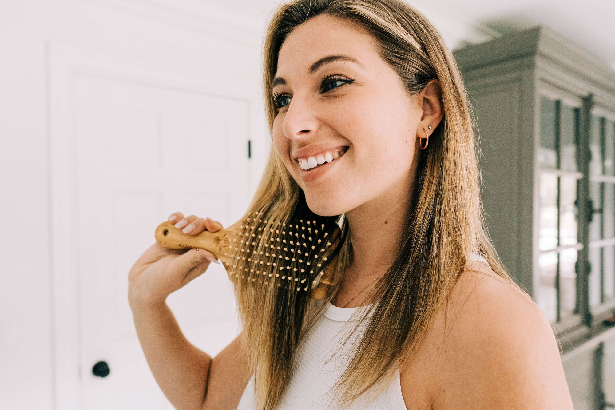 A woman using a bamboo hair brush during her daily routine